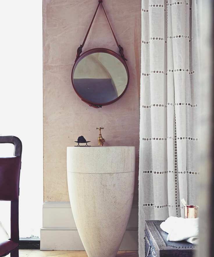 A plaster pink bathroom with a statement sink