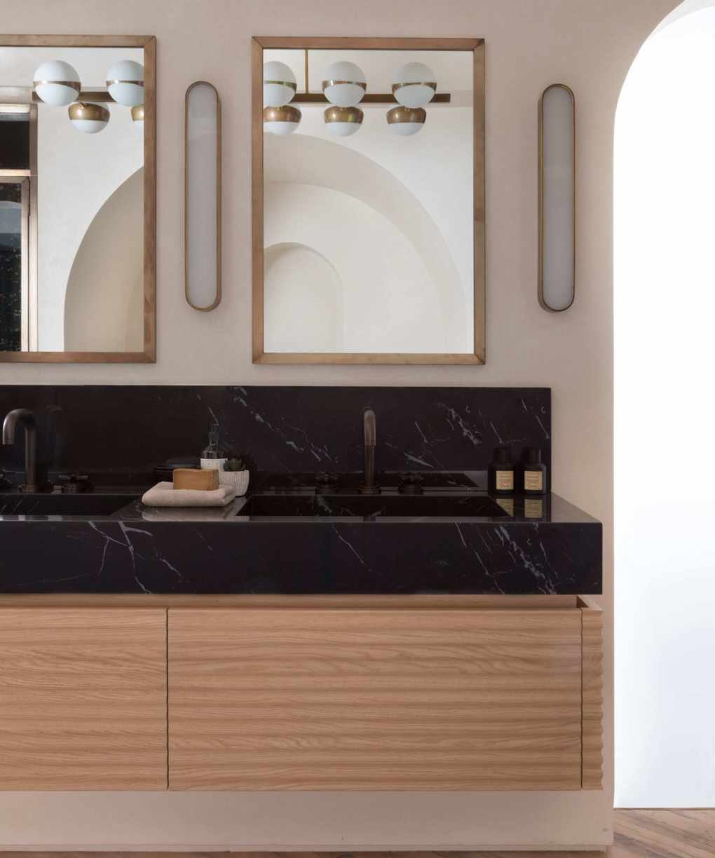 Midcentury bathroom featuring black marble counter and dual sinks