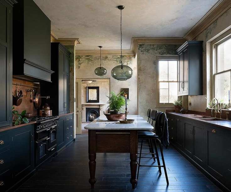 A moody victorian kitchen with dark green cabinets and copper countertops