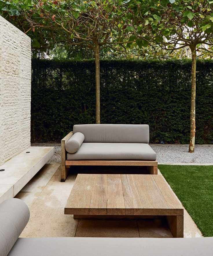 Minimalist patio furniture with sleek lines and neat hedges.