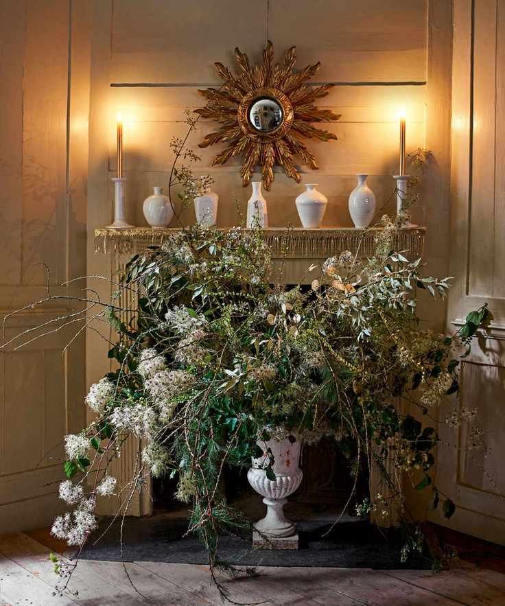 Fireplace decorated with candles, ceramics, and flowers