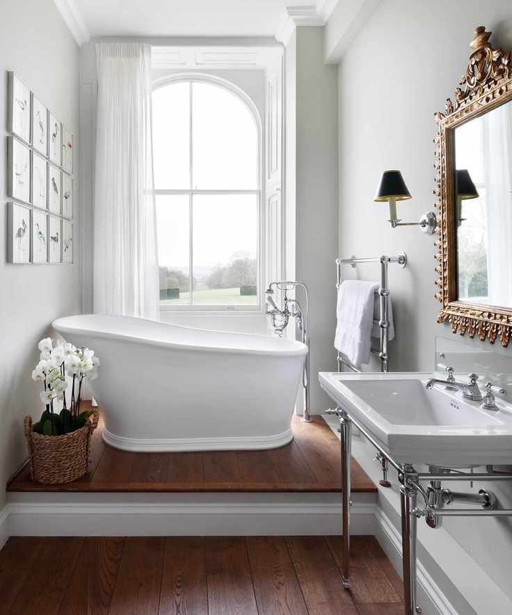 A small bathroom featuring a freestanding bath beneath a window