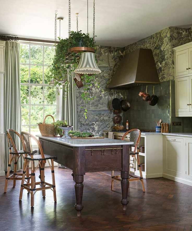 A deep green kitchen covered in a nature inspired wallpaper