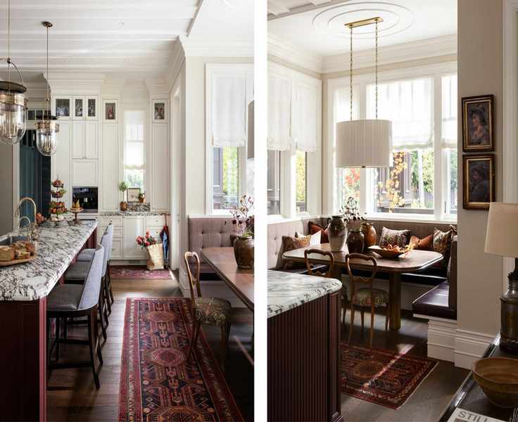 a white traditional kitchen with tall cabinetry, a statement marble countertop and splashback, a dark red island with marble and red vintage rugs