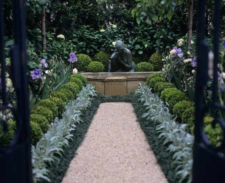 Garden path leading to statue with repeated planting of buxus, stachy and hydrangeas on both sides