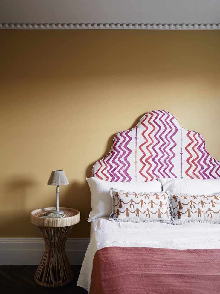 Yellow bedroom with headboard and cornicing