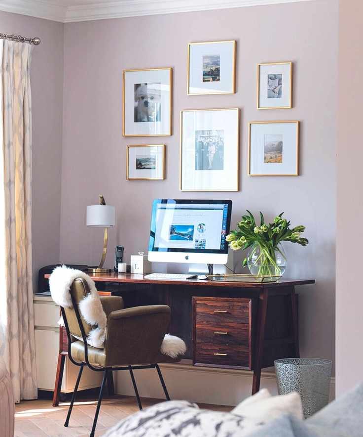 Living room with light blue sofa and pale pink retro style chair, and view through an archway to a study area.