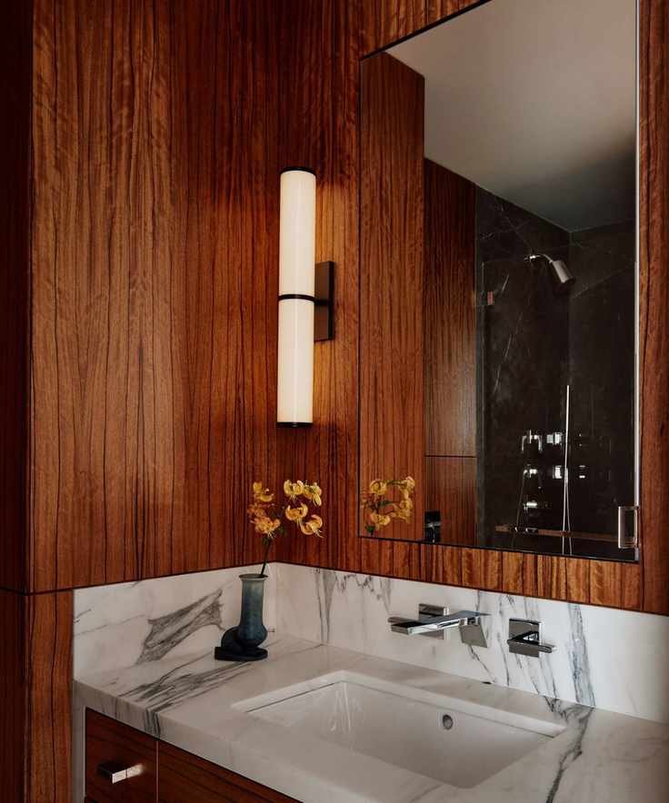 A bathroom with dark wood paneled walls.