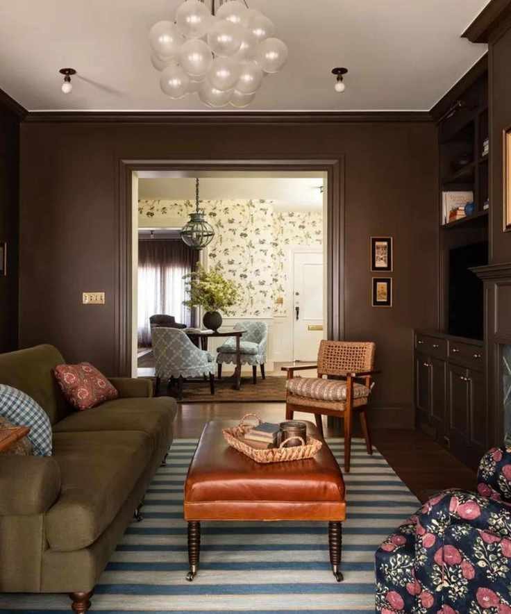 brown painted living room with a green couch and fitted built-in storage