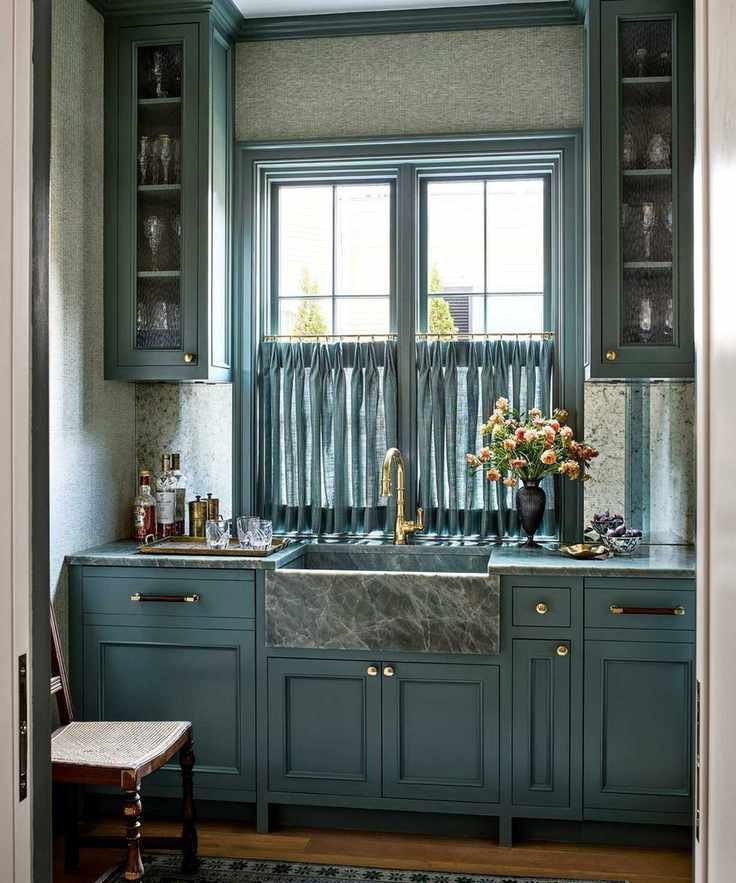 Blue home bar with a marble sink and glassware storage