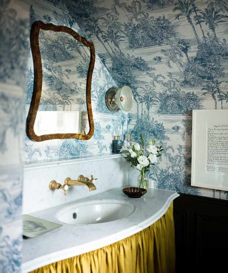 small powder room bathroom with blue and white toile wallpaper, a marble vanity sink with a yellow sink skirt