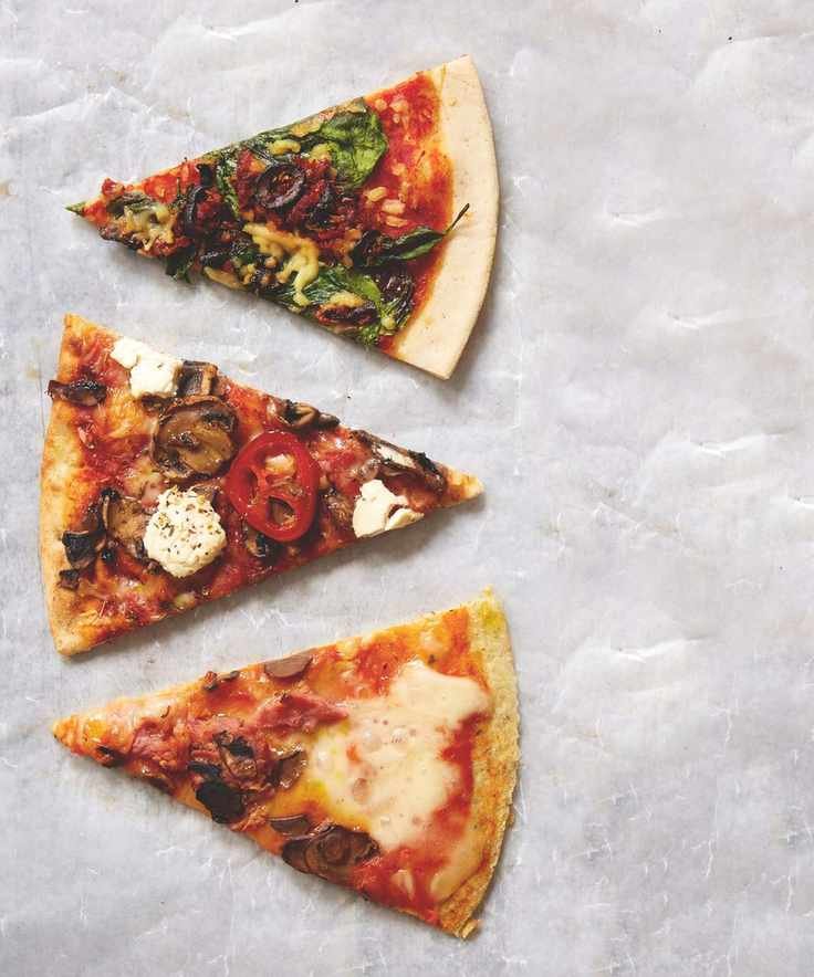 Three different pizza slices on a marble surface