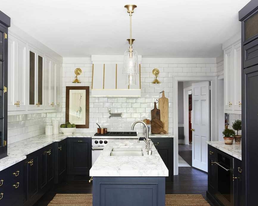 A kitchen with continuous white backsplash tiling and dark blue cabinets, showcasing full wall white kitchen backsplash inspirations.