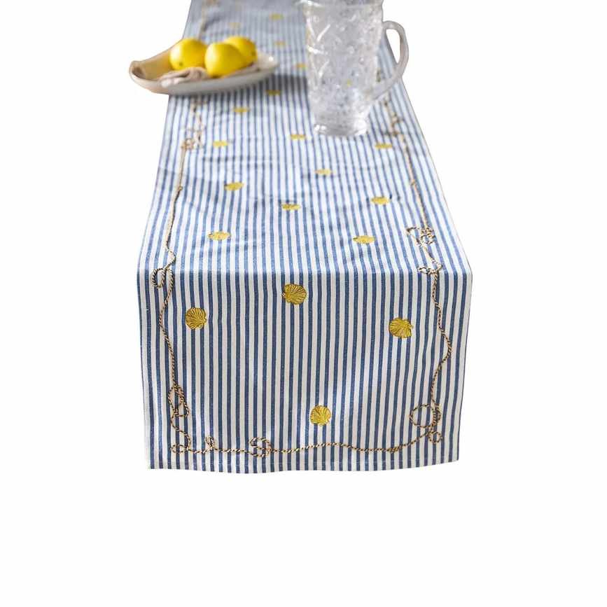 A table runner with white and blue stripes and a pitcher and lemons on top of it