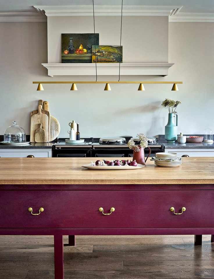 French country kitchen with painted purple island and large range with cream walls
