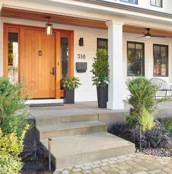 Modern front porch showcasing a wooden ceiling that matches the door
