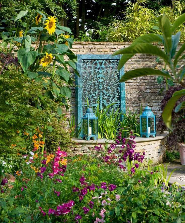 filigree bronze water wall by David Harber in a country garden
