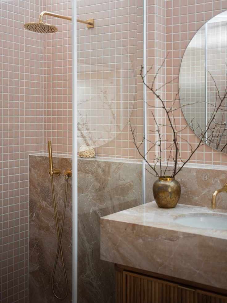 coral bathroom with shower and vanity with marble top. glass doors