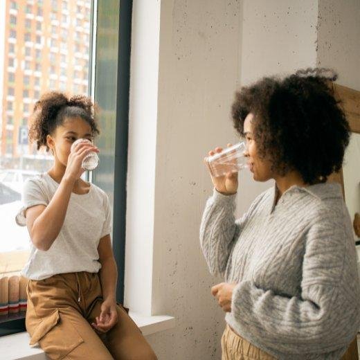 Mother and Daughter drinking water together Mother and Daughter drinking water together