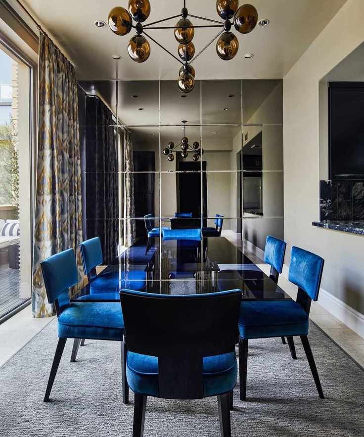 dining room with blue chairs and smoked glass table and feature wall grey rug