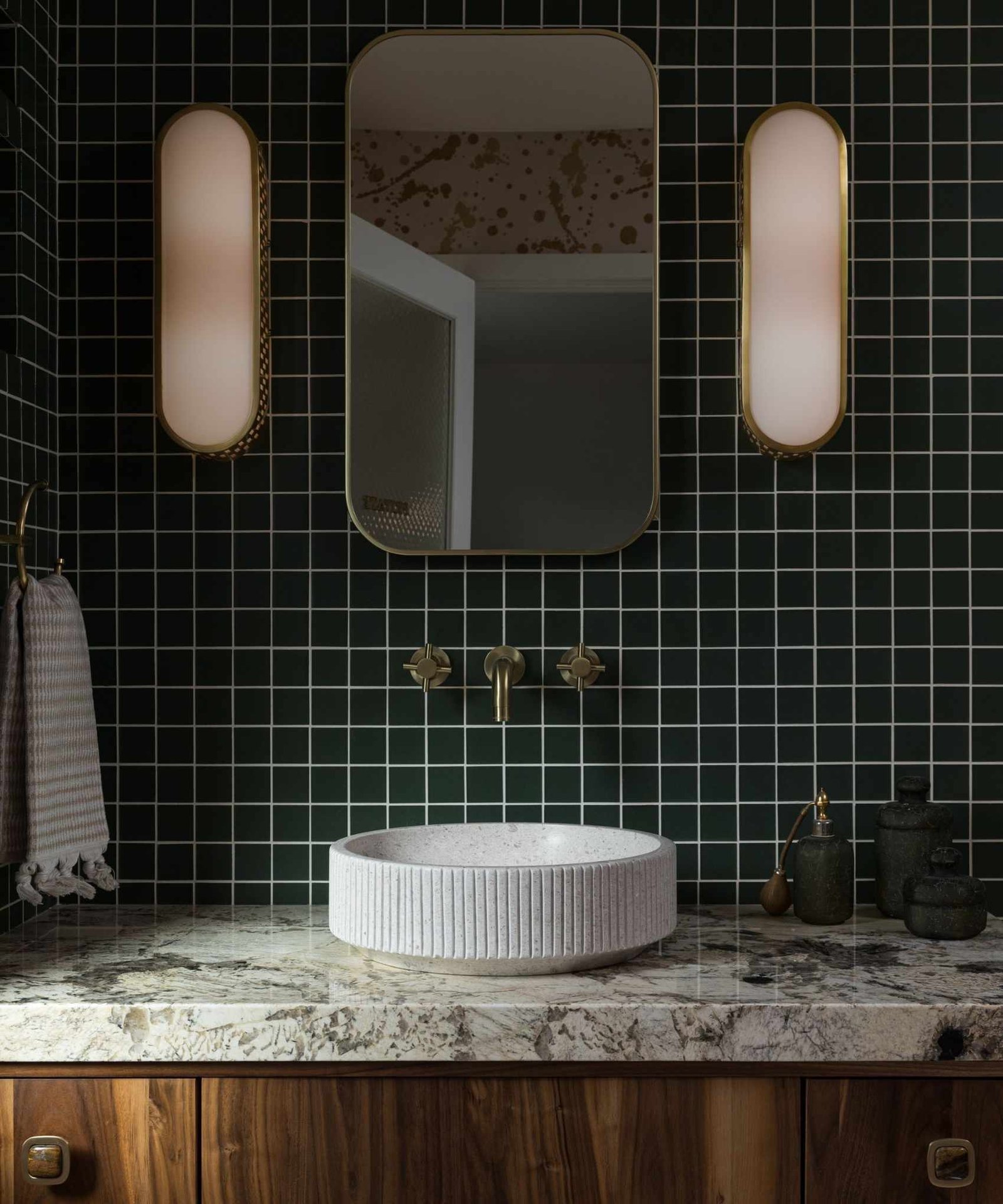 Bathroom with green tiled walls, gold marble and marble countertops