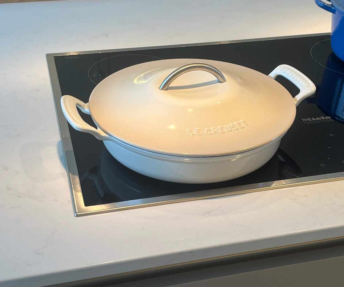 Le Creuset Modern Heritage Braiser with its lid on, on an electric store top.