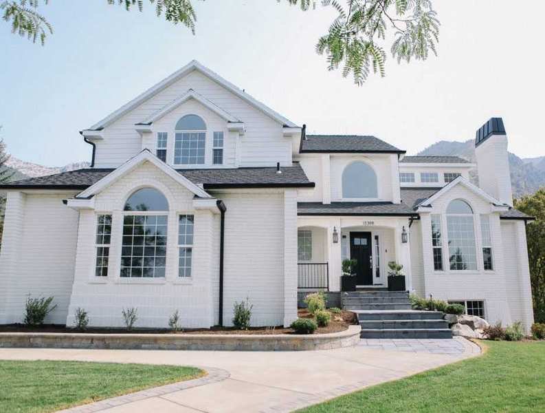A front yard walkway idea with gray steps in front of a white house.