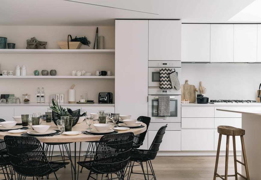 open plan kitchen dining space with open shelving and cabinetry