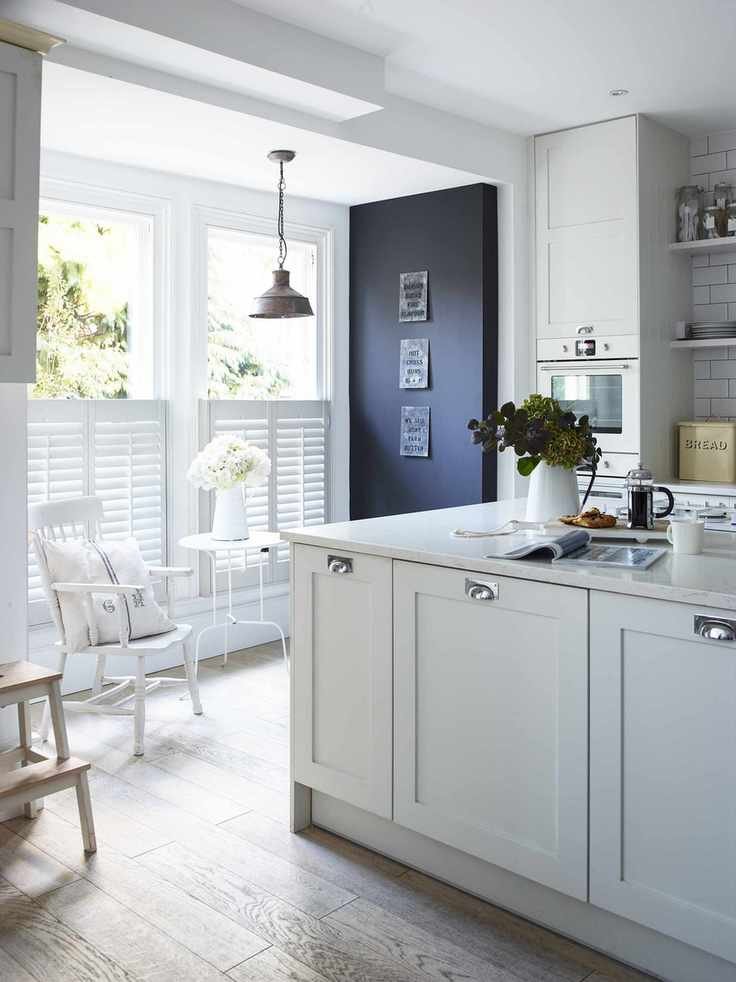 White kitchen ideas featuring painted cabinets and a white tiled backsplash and shutters, and a painted on blackboard.