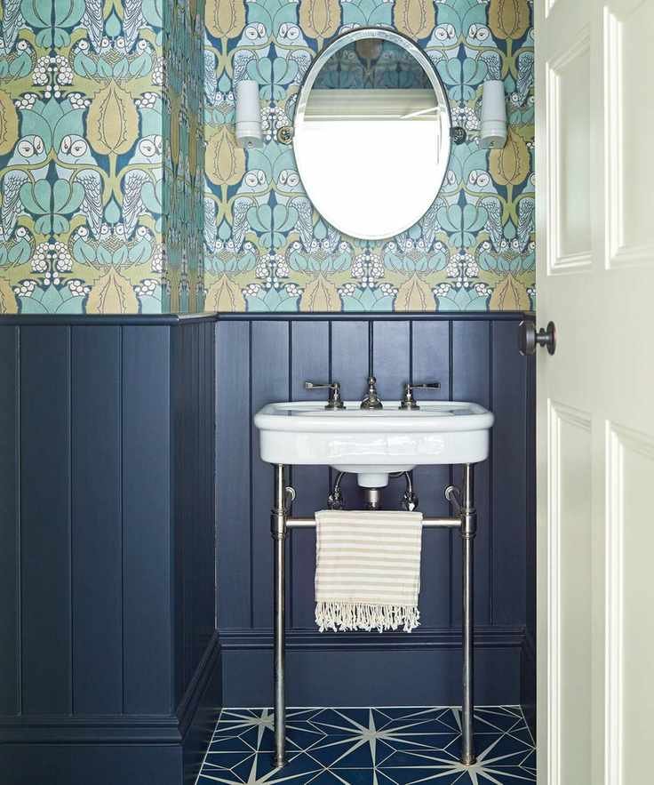 blue bathroom with patterned wallpaper and paneling