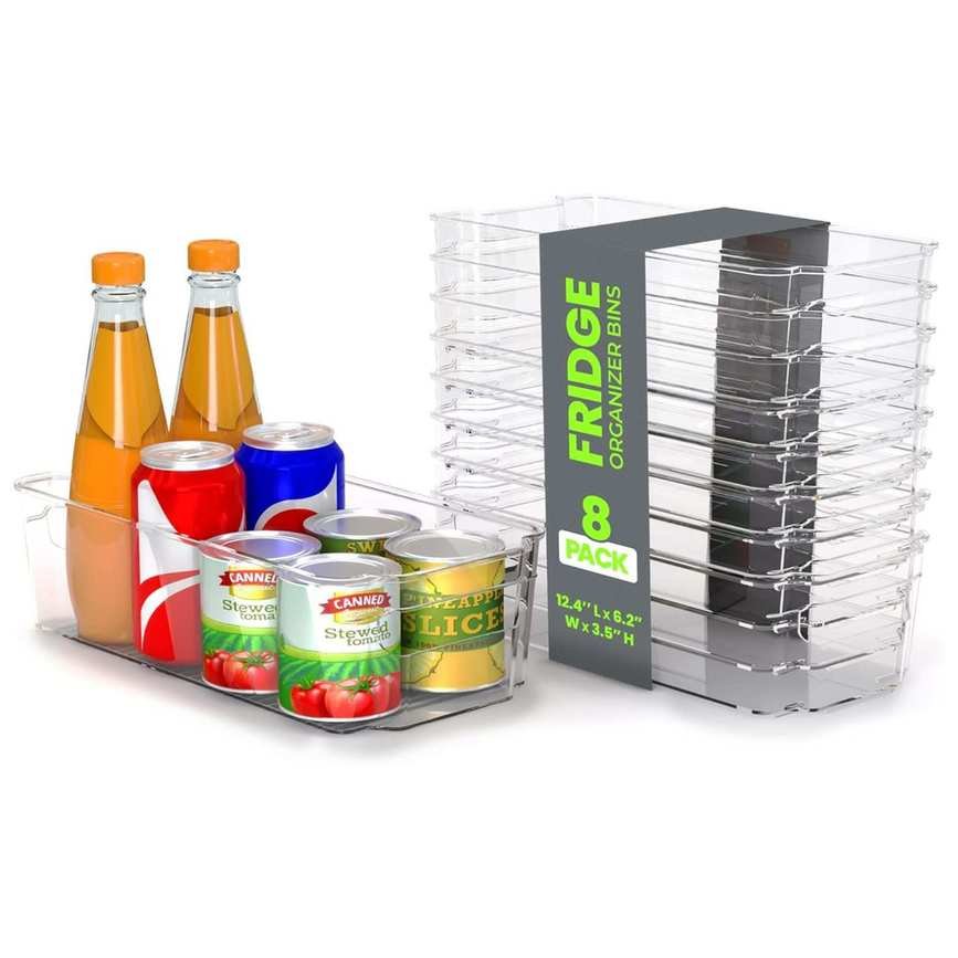 A stack of clear fridge organizer bins. One is filled with tins, cans and bottles.