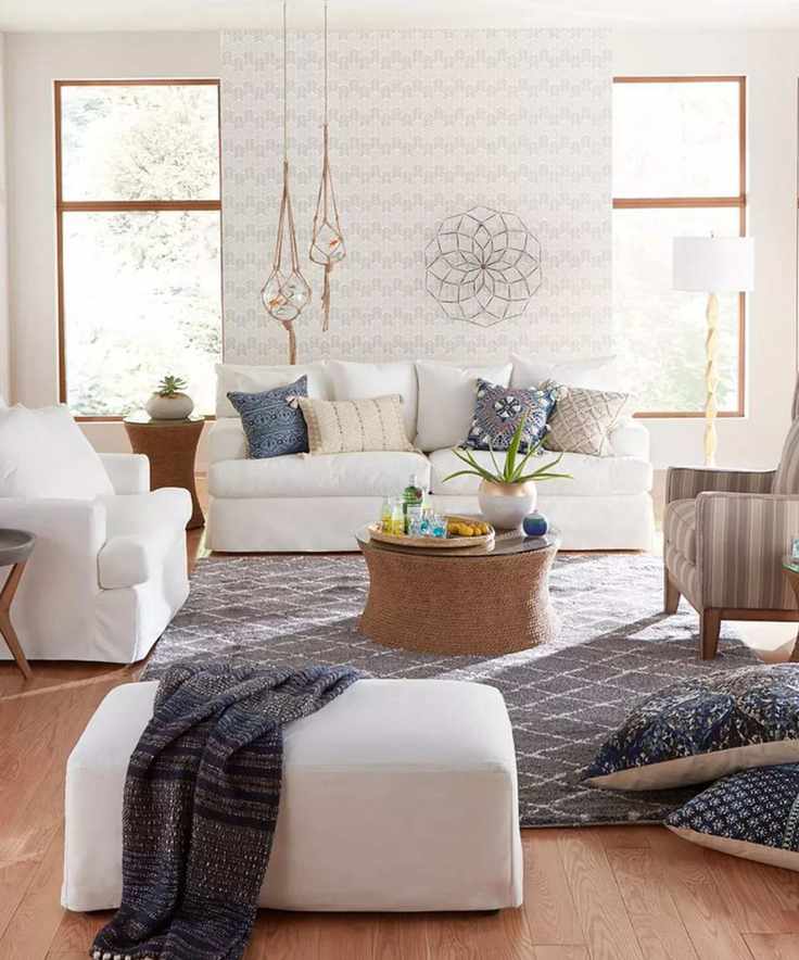 neutral living room with white couch, matching armchair and ottoman with coastal style