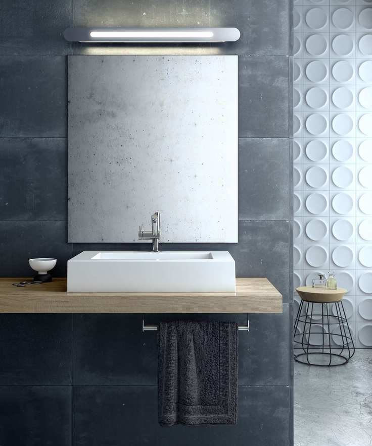 A white sink in front of a gray wall with an LED light above the mirror