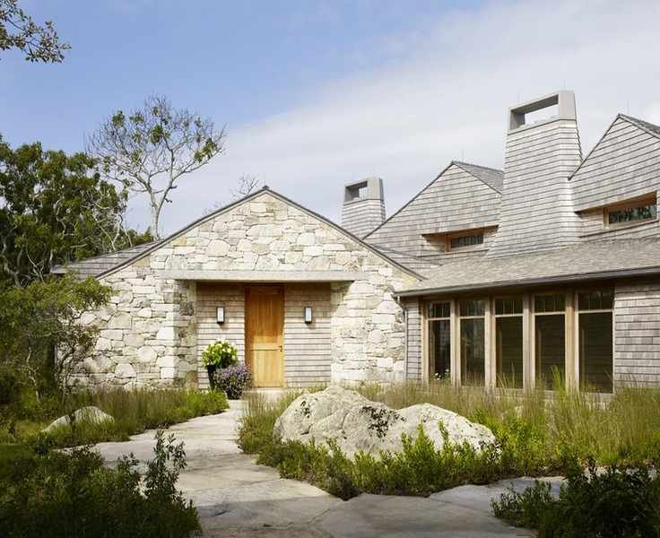 Tall grass and leafy greens around a front yard with large rocks