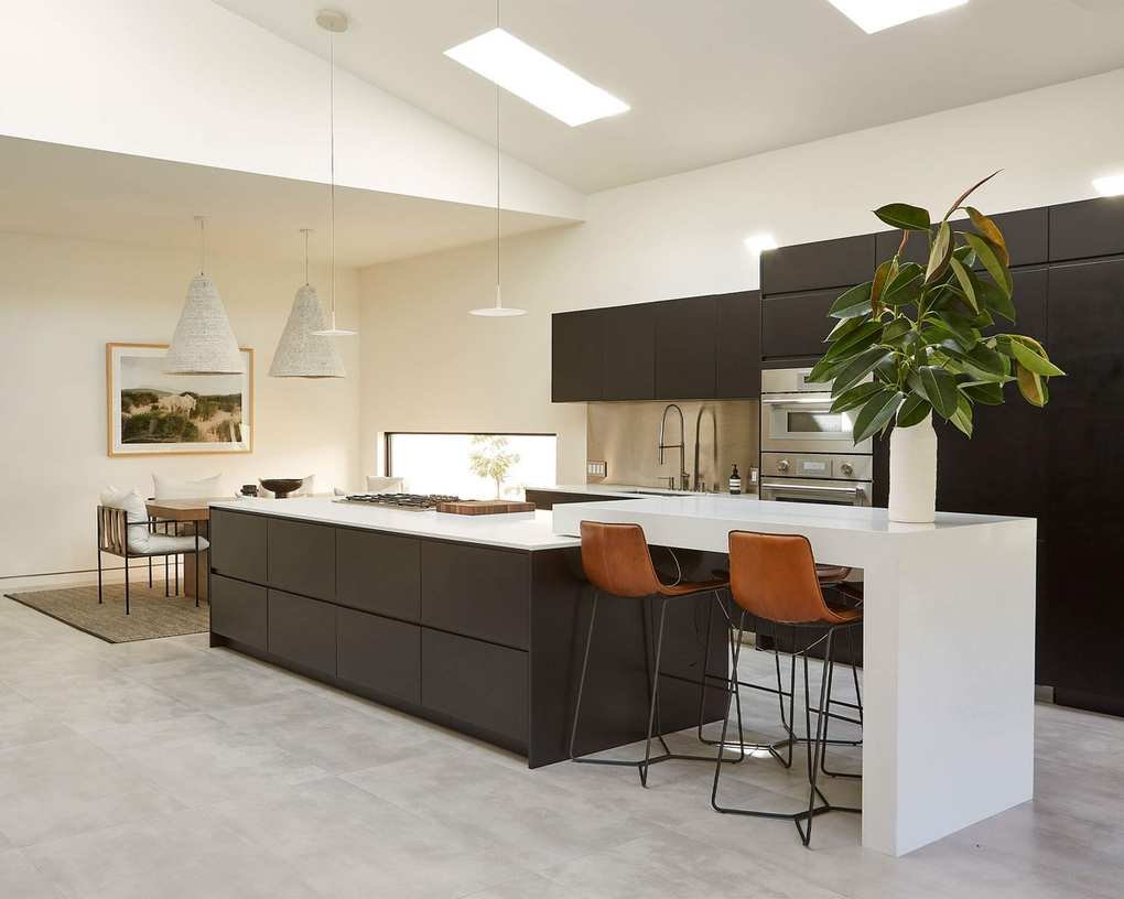 Spacious kitchen-diner with vaulted ceiling and skylights, featuring a large island and modern cabinetry