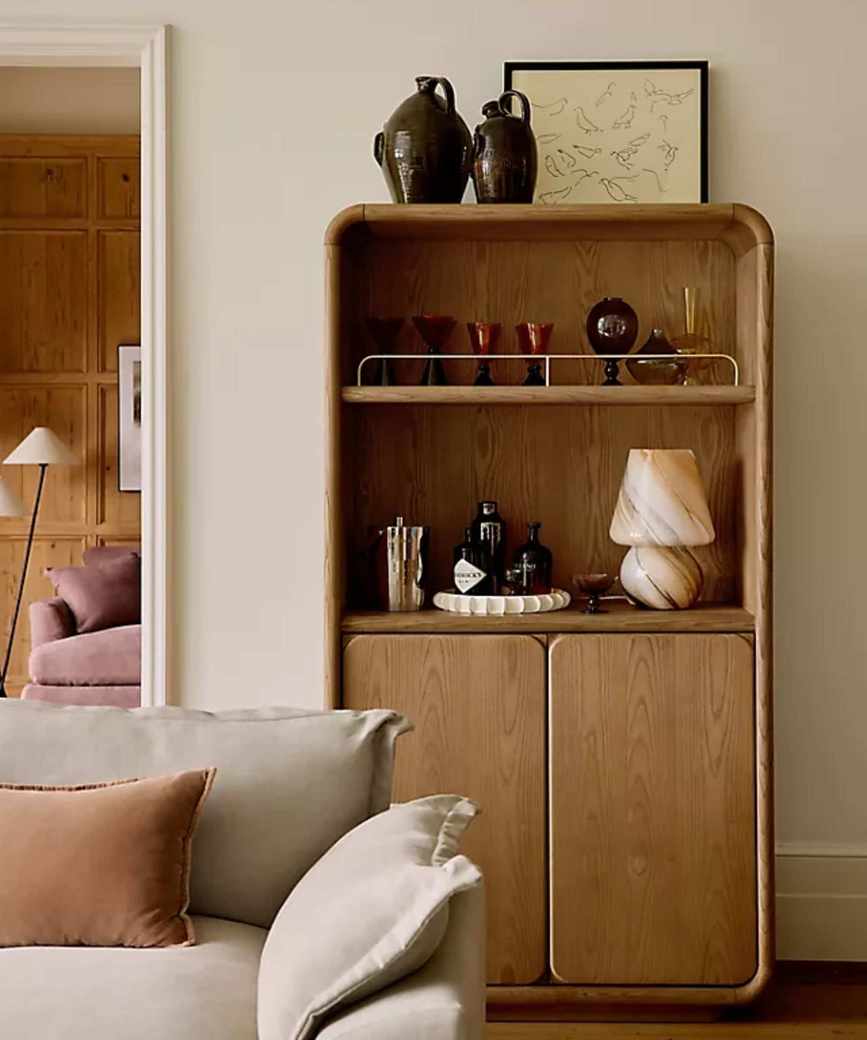neutral living room with velvet couch and a oak cabinet