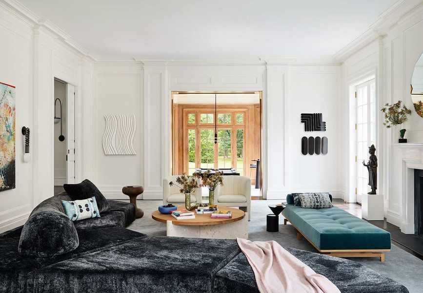 Modern open plan living room with chaise longue, sofa, and modern chairs around a fireplace