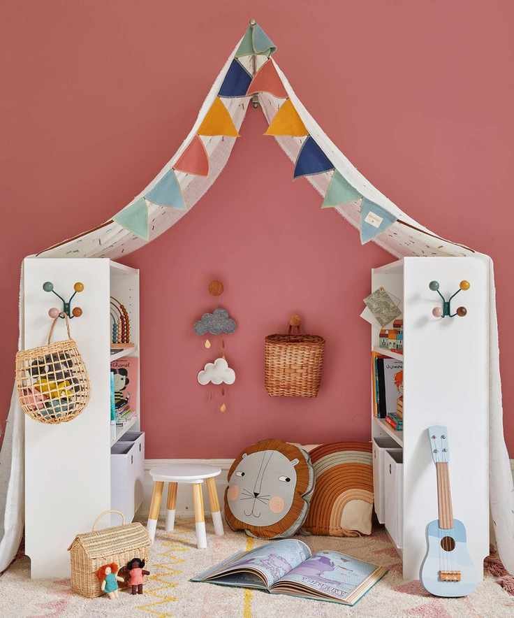 Kids bedroom painted a dark pink, two white storage shelves facing each other