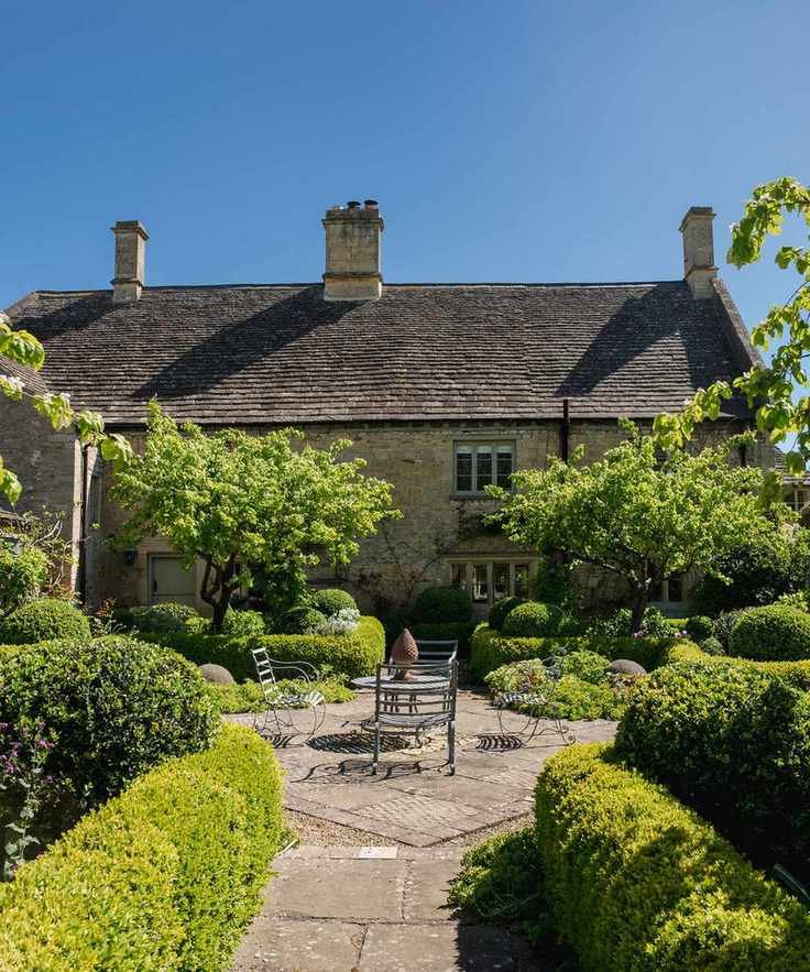A formal courtyard garden with stone pavers, box hedges, white flowers