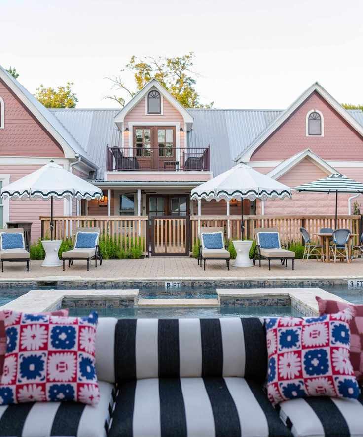 pink house with a pool and striped sofa