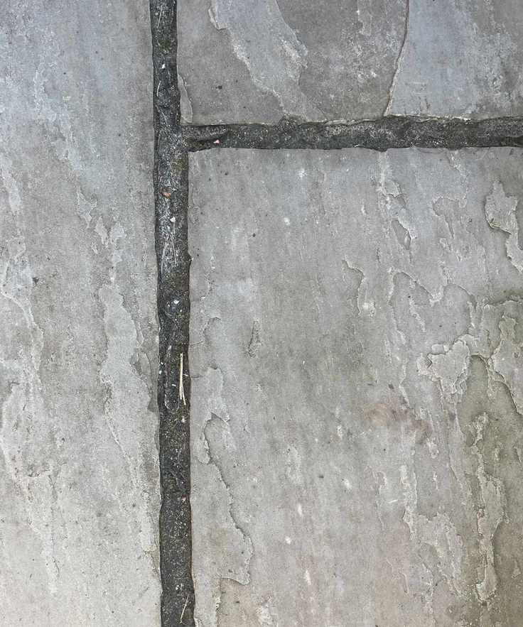 A gray tiled patio, close up of the gaps between tiles.