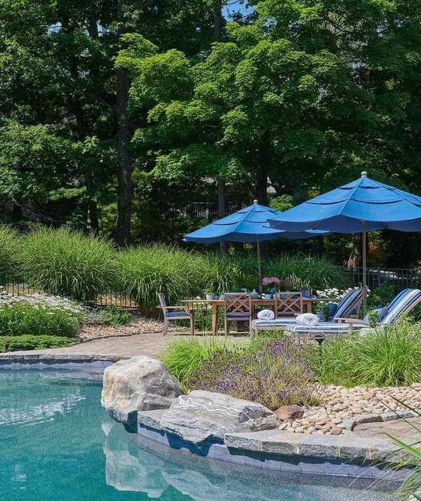 patio next to pool with loungers, table, chairs and umbrella