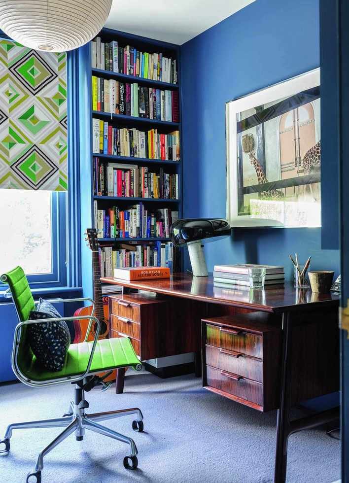 home office with blue walls and dark desk