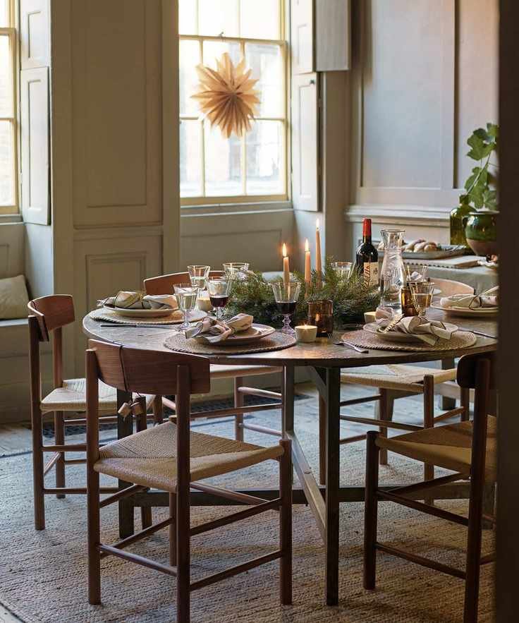 Fall table decor ideas with a round table, fabric napkins in grey, and pine centerpiece