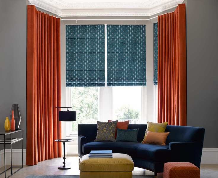 Bay window styled with a mix of blinds and curtains