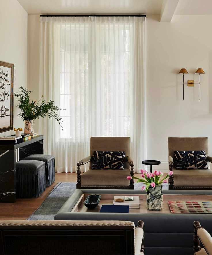 A neutral-toned living room with two chairs and a coffee table