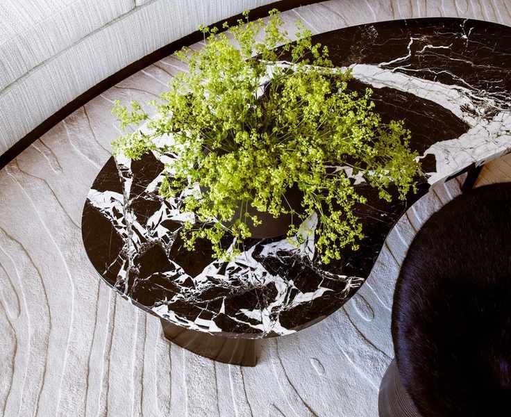 Edge of couch with textured fabric, rug and coffee table