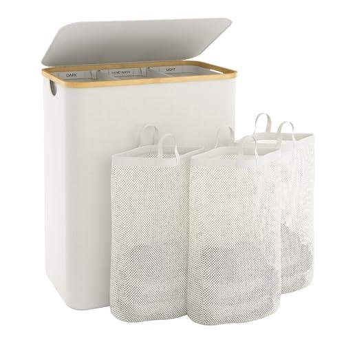 A cream laundry basket with a bamboo trim and flip lid, with three removable mesh bags in front of it.