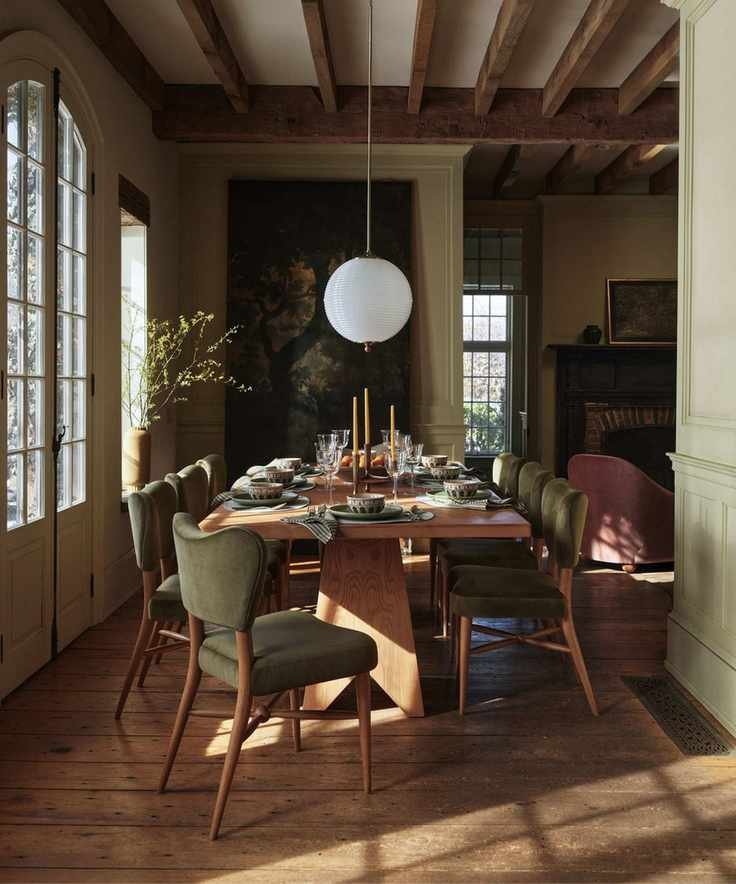 retro eclectic earthy dinng room with a tapestry on the wall and green velvet upholstered dining chairs