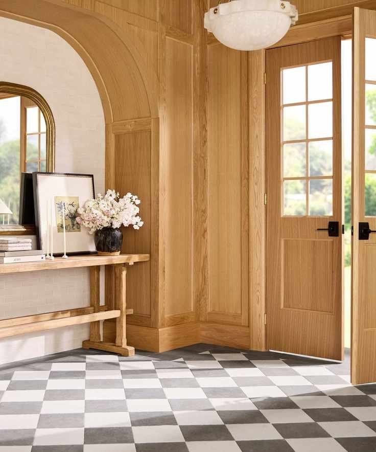 A wooden entryway with black and white tiled floors and an entry table